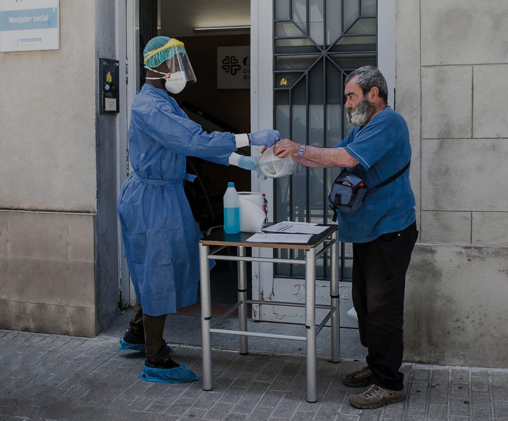 Voluntari de Càritas entregant una bossa d'aliments